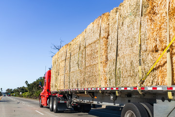 Truck transporting bales of hay on a freeway in Ventura County, South California