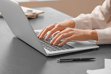 Beautiful secretary working on laptop in office, closeup