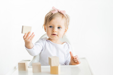 Little child shows wooden block. Children educatoinal by the Montessori method. Eco friendly wood toys. Toddler isolated on white background.