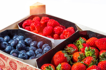 Fresh bluberries, raspberries and strawberries in a wooden box, close up