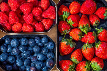 Fresh bluberries, raspberries and strawberries in a wooden box. Top view