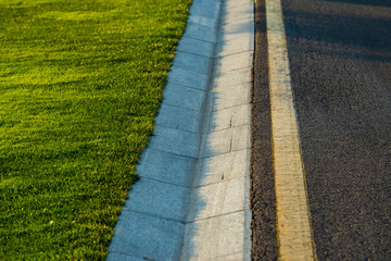 stone drain with asphalt and green lawn in the park