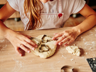 Girl makes cookies from the dough in the kitchen. heart shape