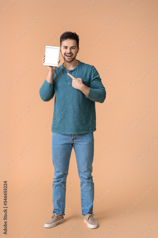 Poster young man with tablet computer on color background