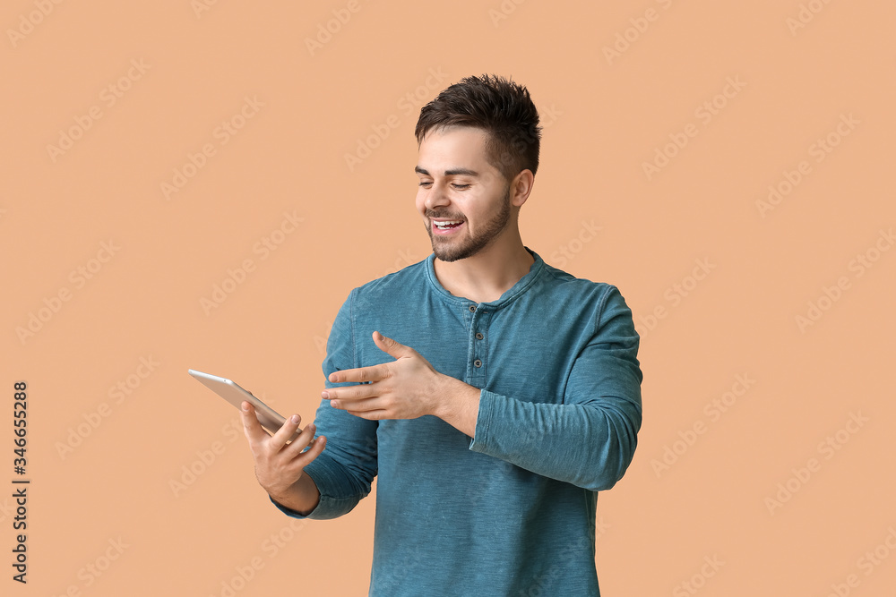 Poster young man with tablet computer on color background