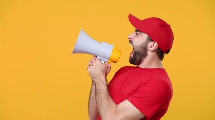 Fun crazy delivery man in red cap blank t-shirt workwear scream in megaphone announces discounts sale Hurry up isolated on yellow background studio Professional male employee courier Service concept