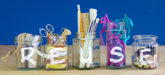 Recycled jars reused for storing crafting materials with reuse text, recycling at home for sustainable living, save money and zero waste