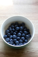 Bowl of fresh blueberries on a table. Selective focus.