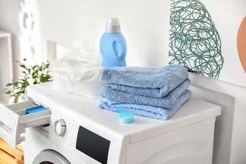 Obraz na płótnie Canvas Detergent and clean towels on washing machine