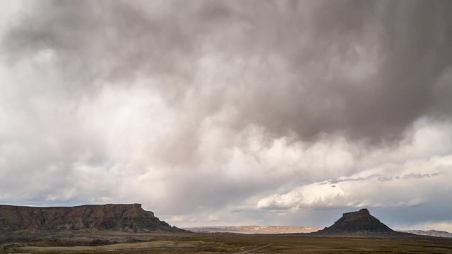 Storm moving across the sky over the Utah desert with Factory Butte.