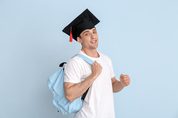 Young man in graduation hat on light background
