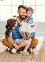 Happy father receiving greeting card from kids.
