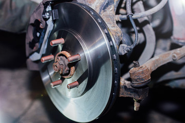 installation of a ventilated brake disc of a car on a hub in a garage. brake system repair