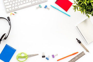 E-learning. Stationery, headphones and keyboard on white table top-down frame copy space