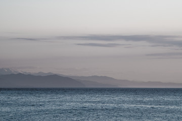 Mountain view from the beach. Sea coast made of pebbles. Ripples on the Black Sea. Spring, sunny...
