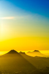 Silhouetted Mountain at Sunset with Yellow Rays 