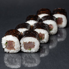 diverse delicious sushi roll set on a black background with reflection, menu