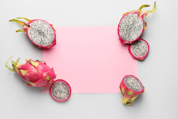 Tasty dragon fruit with paper sheet on grey background