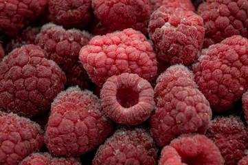 Food background concept with full frame close up of frozen raspberries covered with frost