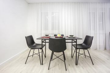 Interior of the modern luxure kitchen with guest table in studio apartments in minimalistic style with dark red color