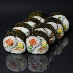 diverse delicious sushi roll set on a black background with reflection, menu