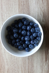 Bowl of fresh blueberries on a table. Top view.