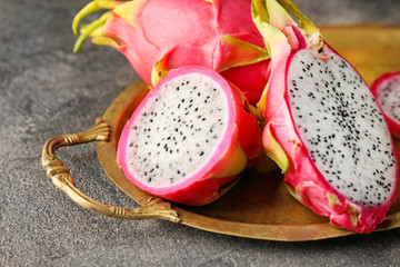 Tray with tasty dragon fruit on dark background