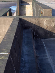 concrete stairs on seawall in blackpool with the beach at low tide in sunlight