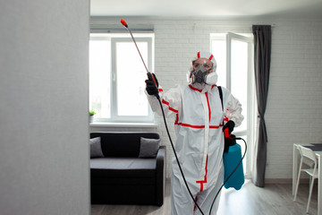 chemical cleaning of the room, a man in a protective suit cleans the apartment of infections with a...
