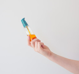 Girl holds cosmetic oil in blank vial blank with pump. Sea buckthorn oil for the treatment and rejuvenation of the skin