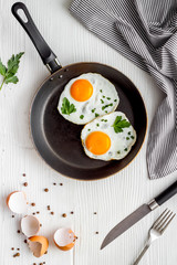 Fried egg on frying pan on white table top view