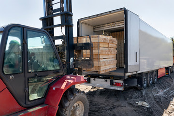 The machine loads the boards, lumber from the finished goods warehouse onto the truck
