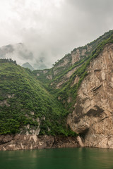 Xiangxicun, China - May 6, 2010: Xiling gorge on Yangtze River. Cleavage separates brown rock cliff...