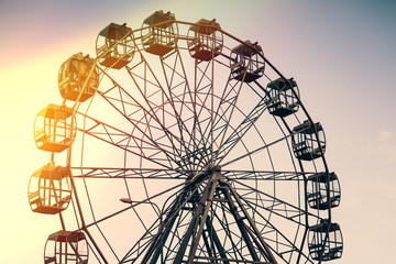 Ferris wheel on a background of sun flare. Contrast photo overlooking the sky.