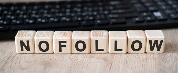 Nofollow links - concept text on wooden cubes and in the background black keyboard