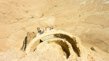 Aerial photo of the Masada Fortress in Israel in the Judaean Desert, with a group of tourists on...