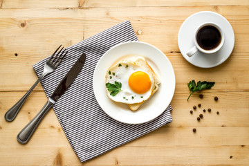 Fried egg on plate on wooden table top view copy space