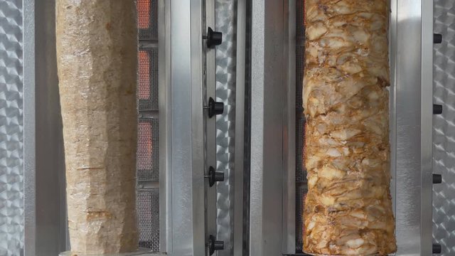Beef and chicken kebab being cooked in a grill machine.