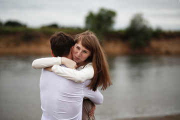 beautiful couple embraces on the beach. The concept of hugs and breakups. Feelings and emotions. Portrait of a woman and a man in close-up.