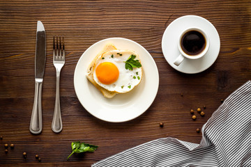 Fried eggs, coffee for breakfast on wooden table top view