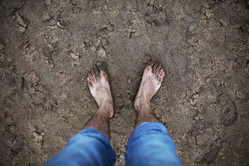 Tanned tired feet stand on the hot river sand. Concept of tourism and travel