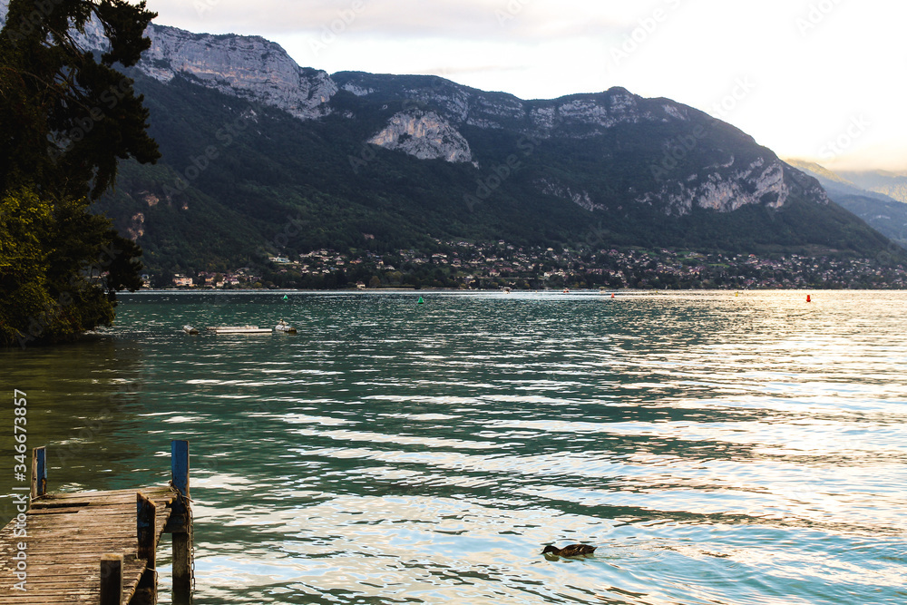 Wall mural the iles des cygnes at sunset, a famous artificial island on lake annecy (lac d'annecy) with the fre