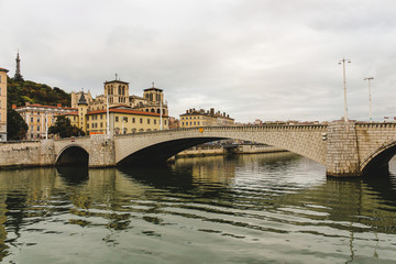 Fototapeta premium The Pont Bonaparte over the Saone river, the Basilica of Notre-Dame de Fourvièrel, Quai Fulchiron (quay), the Lyon Cathedral and the 5th Library St John Episcopal, France.