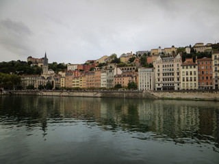 Fototapeta na wymiar Heading into Vieux Lyon over the Pont Bonaparte. Quai Fulchiron on the banks of the Saone river, Passerelle, Saint Georges church and Saint-Just College on Fourviere hill.