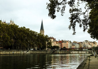 Fototapeta na wymiar Church of St George with buildings along the Saone River, Quai Fulchiron (quay), in the Old City of Lyon, in the 5th arrondissement (district), Passerelle Saint-Georges bridge, and the Fourviere hill.