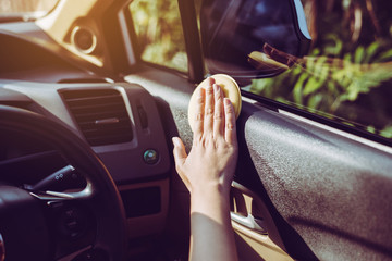 Woman worker cleaning with sponge in modern car,Cleansing car interior for protection from virus...
