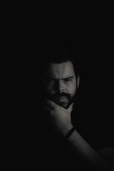 Bearded man face on a black backgroud in low key