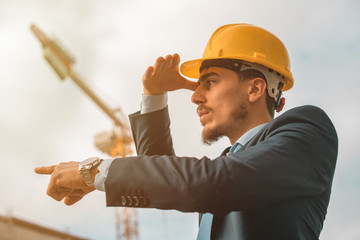Young construction engineer with yellow helmet crane and construction background , Turkey,Civil engineer ,construction Plan