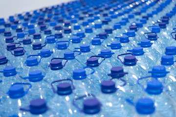 Lot of bottles worth with clean cool natural water. Group of plastic bottles with water stand in a row.