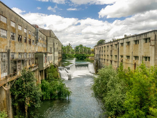 Fototapeta premium Old paper factory near river with waterfalls. Nabao River, Matrena factory in Tomar, Portugal.